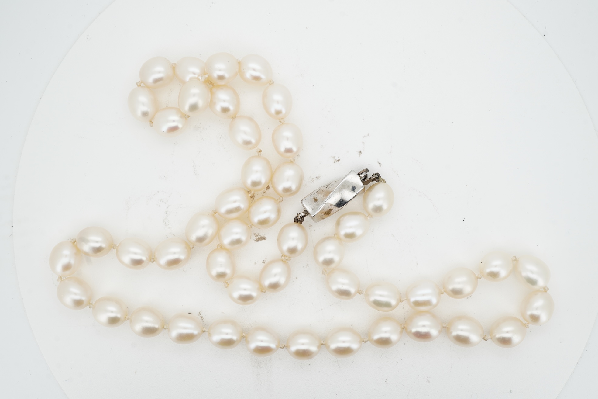 Tiffany & Co., a pair of diamond earrings and a cultured pearl necklace, the earrings of cross design, set with brilliant-cut diamonds totalling approximately 0.30 carats, mounted in platinum, length approximately 0.7cm